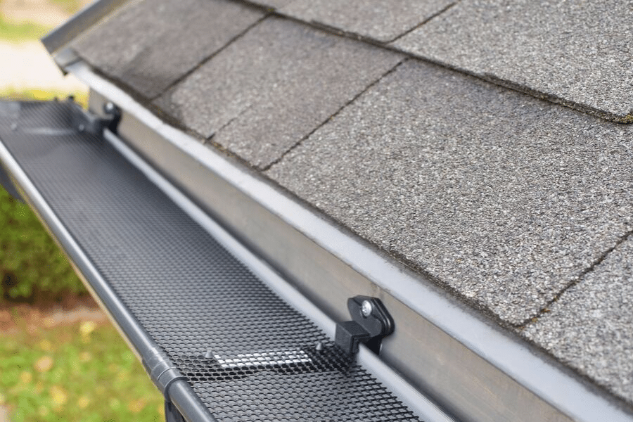 A stainless steel screen placed during gutter guard installation.